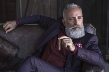 Eski işadamı tütün tutmak sakin sakallı