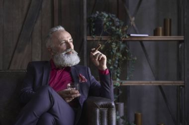 Sakallı memnun emekli dinlenme kanepede sahip