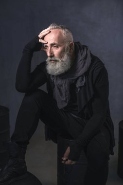 Düşünceli sakallı kıdemli demir fıçılar üzerinde bulma