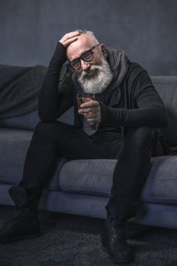 Gülen emekli kanepede lezzetli içecek tatma