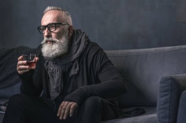 Sakin yaşlı adam kanepede sıvı içme