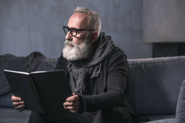 Düşünceli yaşlı adam ilginç kitap okuma