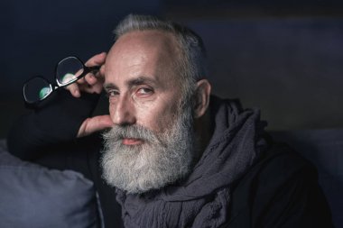 Ciddi yaşlı adam kanepede bulma