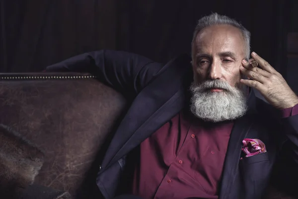 Thoughtful bearded senior keeping tobacco — Stock Photo, Image