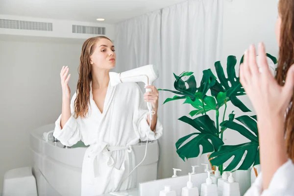 Mujer joven y pensativa secándose el pelo en el baño — Foto de Stock