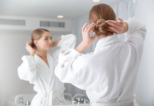 Vacker flicka gör frisyr i badrum — Stockfoto