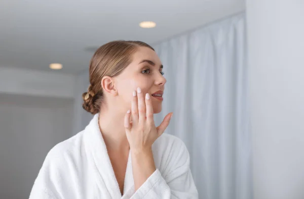 Sensuele jongedame toepassing crème op haar gezicht — Stockfoto