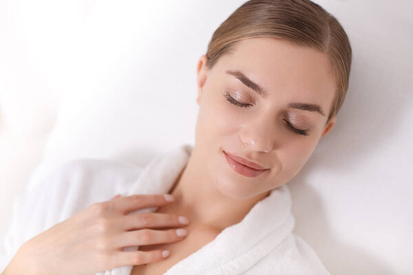 Мечтательная девушка отдыхает на кроватях в оздоровительном центре
