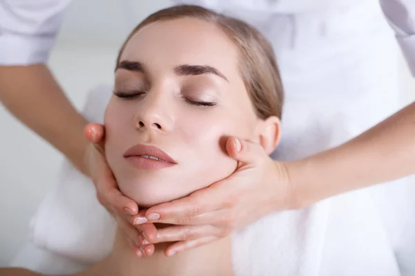 Menina relaxada recebendo massagem facial no spa — Fotografia de Stock