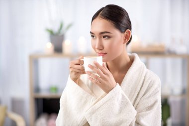 Sevimli genç kadın Sağlık Merkezi içecek keyif alıyor