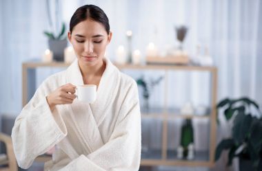 Çekici kadın sıcak içecek tadını çıkarırken kaplıcada dinleniyor