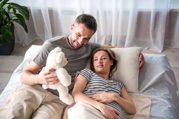 Blij dat toekomstige vader zacht stuk speelgoed geven zijn zwangere vrouw — Stockfoto