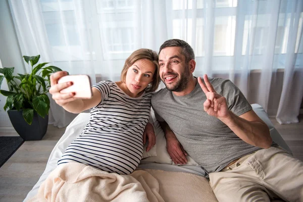 Marito gioioso e moglie in attesa fotografarsi al telefono — Foto Stock