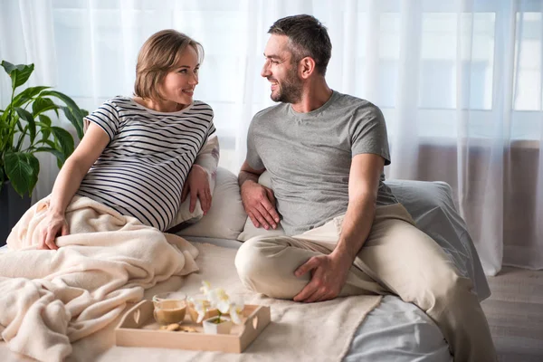 Blij dat toekomstige ouders samen ontspannen in slaapkamer — Stockfoto