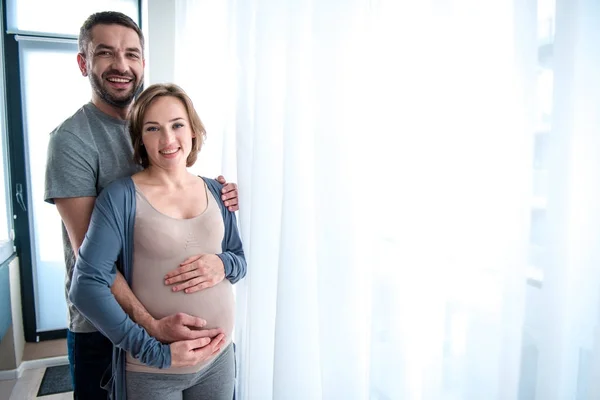Vidám ember átfogó terhes nő otthon — Stock Fotó