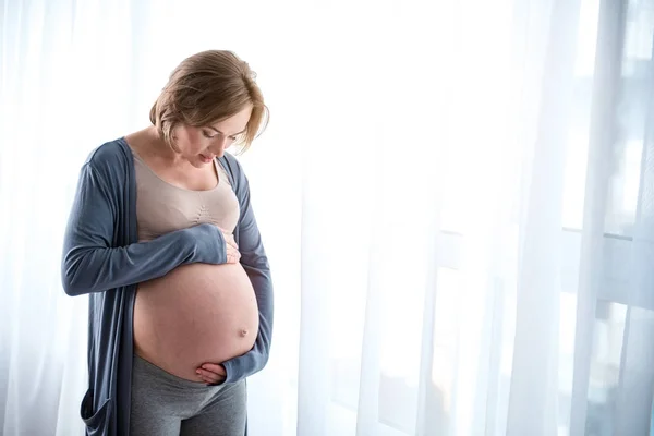 Serena embarazada madre tocando su barriga —  Fotos de Stock