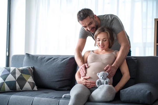 Marido alegre cuidando de sua esposa grávida — Fotografia de Stock