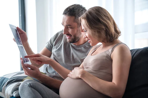 Upphetsad gift par tittar på röntgen bild av ofödda barn — Stockfoto