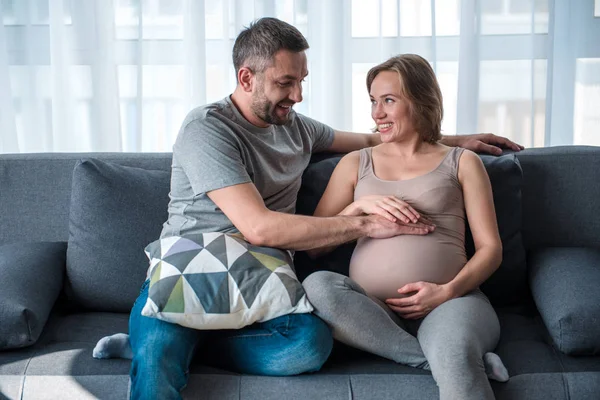 Veselý manželský pár dotýká těhotné bříško — Stock fotografie