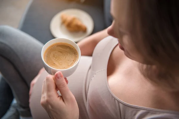Спокійна вагітна жінка п'є каву вдома — стокове фото