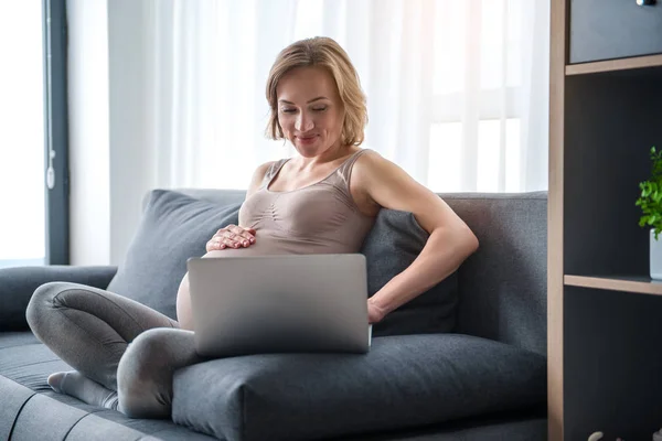 Щаслива вагітна жінка використовує ноутбук вдома — стокове фото
