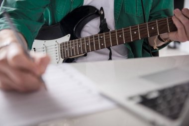 Erkek gitarist melodi müzik aleti oynamak için yazma