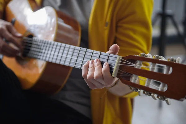 Молодой гитарист исполняет мелодию на музыкальном инструменте — стоковое фото