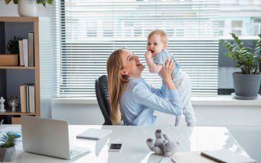 Mutlu çocuk ile oynarken annesi gülümseyerek