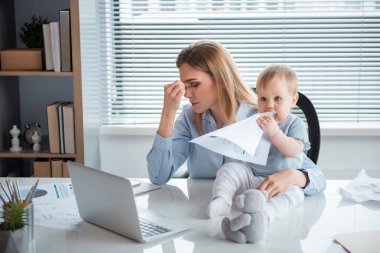 Tired woman with engaged child at job clipart