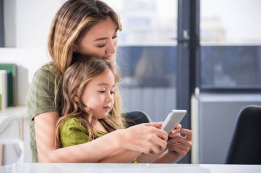 Neşeli Asyalı kız annesi ile tablet kullanma