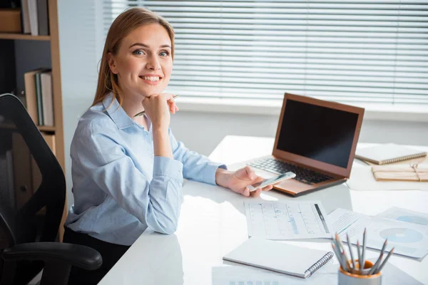 Happy female writing in phone at workplace — Stock Photo, Image