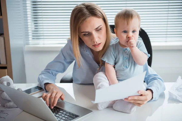 Calm mother having job with child