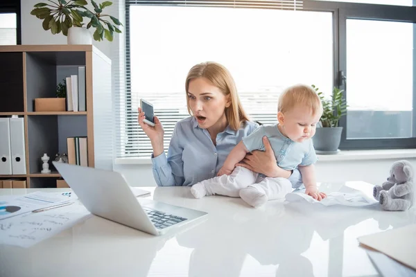 Surprised mother watching at laptop