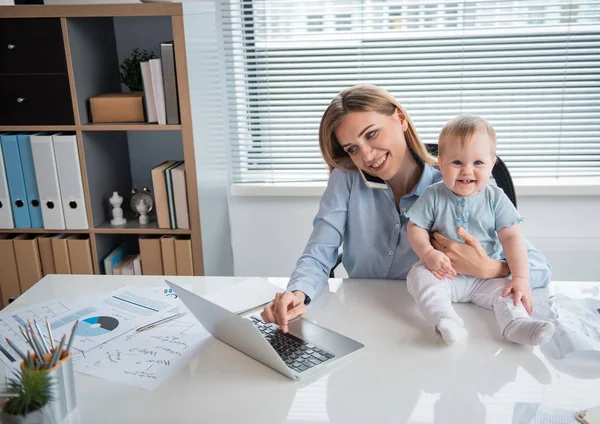 Veselý baby a máma pracuje u stolu — Stock fotografie