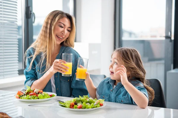 Glad asian woman and girl drinking orange juice — Stock Photo, Image