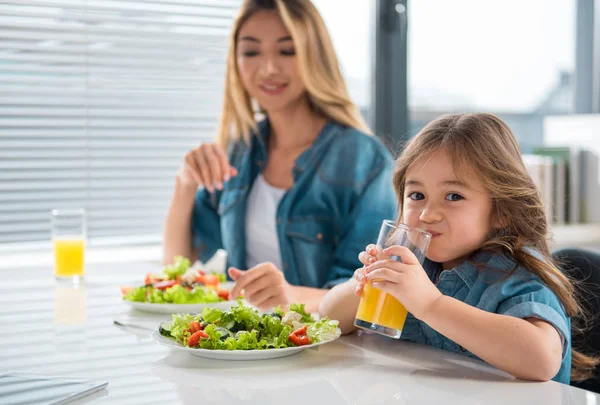 Cute daughter enjoying healthy food and drink — Stock Photo, Image