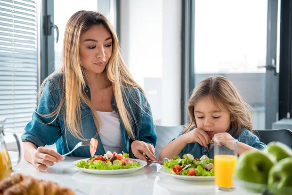 Parent and child eating fresh chopped vegetables — Stock Photo, Image