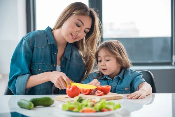 Happy woman preparing salad for her daughter — Stock Photo, Image