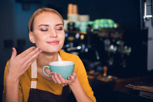 Усміхнена жінка вдихає напій у кафе — стокове фото