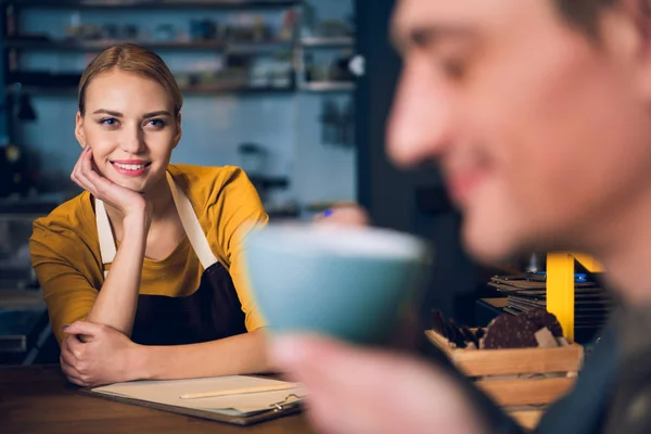 Feliz chica joven mirando en el cliente en la cafetería — Foto de Stock