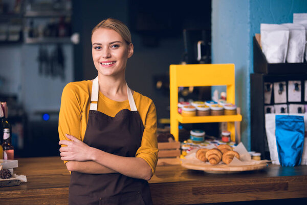 Улыбающаяся работница, находящаяся в кафе
