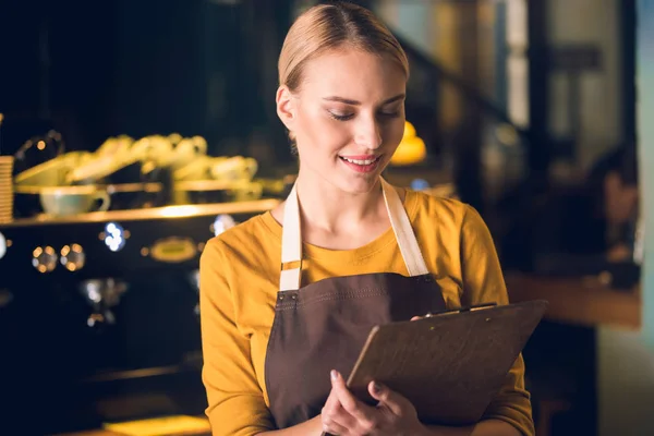 Beaming barista leer información en confitería — Foto de Stock