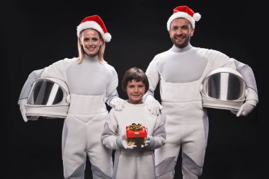 Happy couple of cosmonauts with child are enjoying holiday clipart