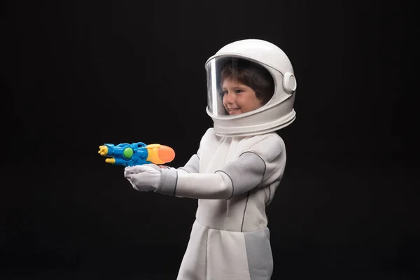 Cosmonaute joyeux joue avec une arme de poing — Photo