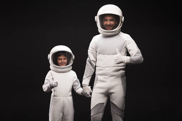 Positive cosmonauts man and boy are expressing joy