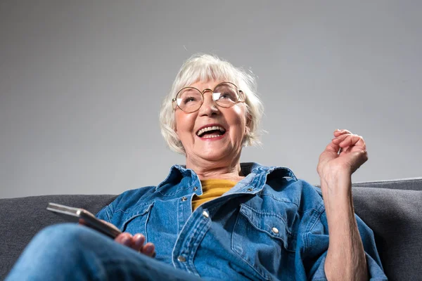 Emozionata vecchia donna che esprime felicità mentre riceve il messaggio al telefono — Foto Stock