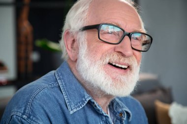 Evde oturan neşeli gülümseyen emekli