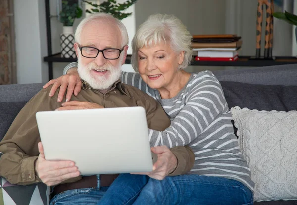 Surprised aged pensioners enjoying rest with laptop — Stock Photo, Image