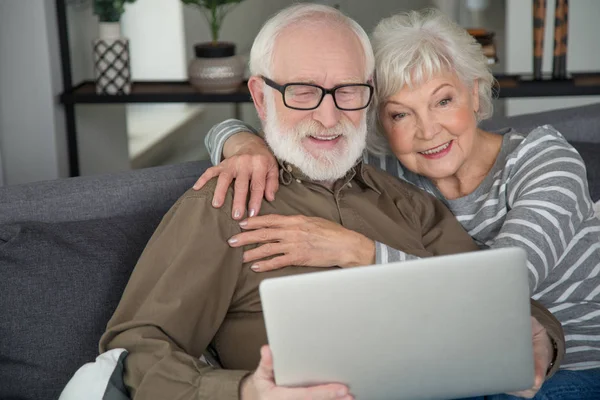 Encantados marido y mujer mirando en el cuaderno — Foto de Stock