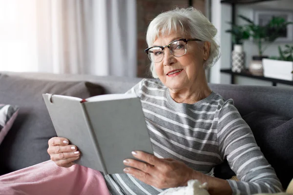 Старша леді тримає книгу з радістю — стокове фото